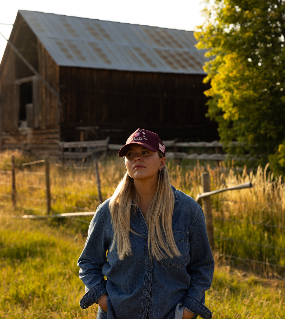Woman in a Bull River cap and denim beside a barn