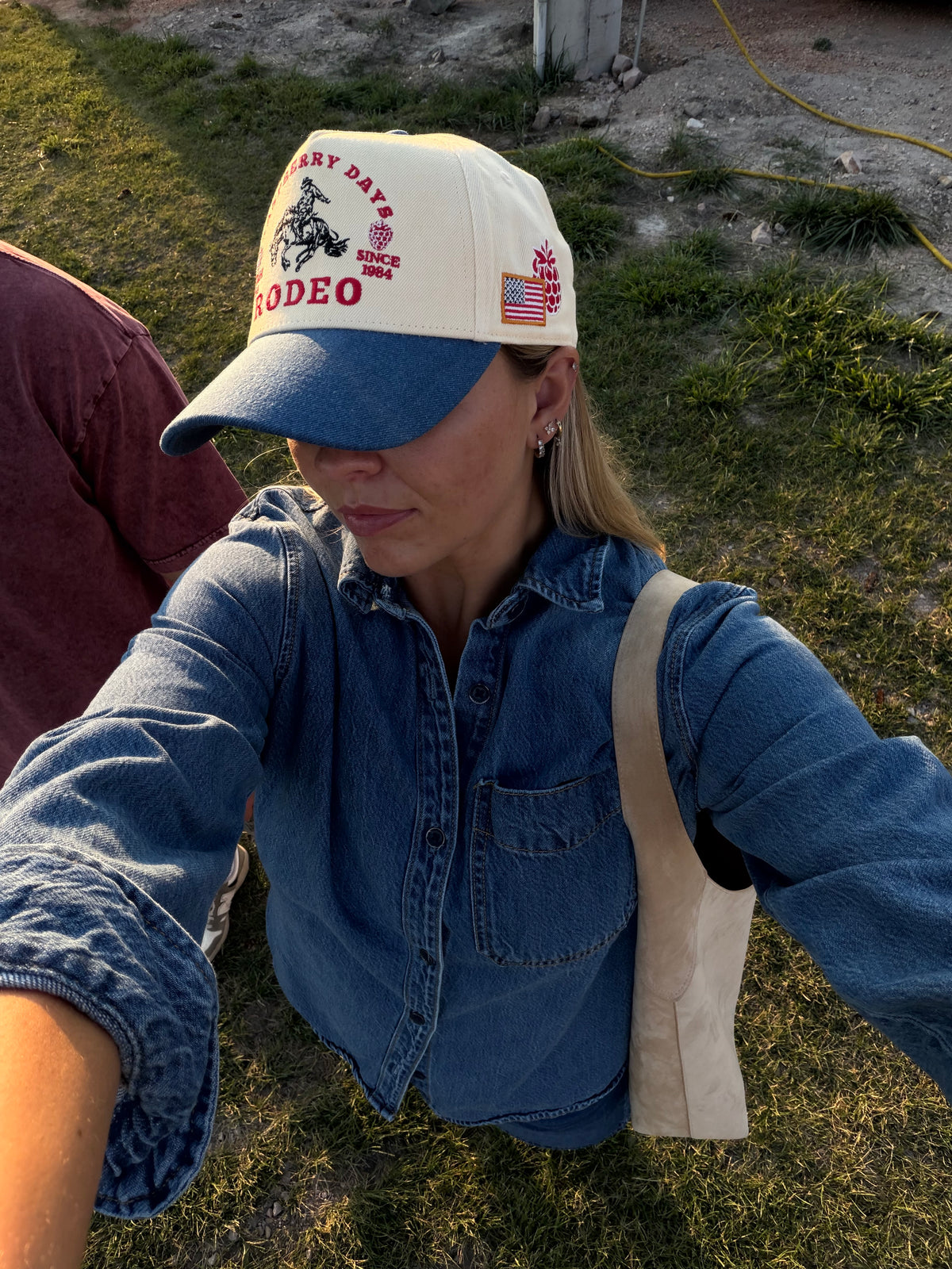 Woman in a denim jacket and Bull River Raspberry Days cap