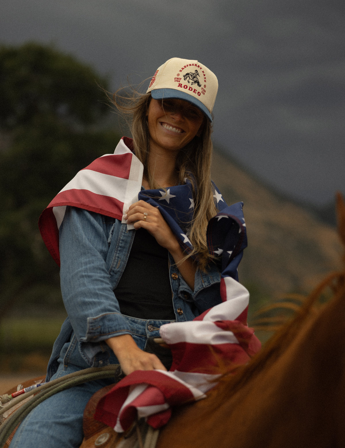 Rider draped in an American flag wearing a Bull River cap