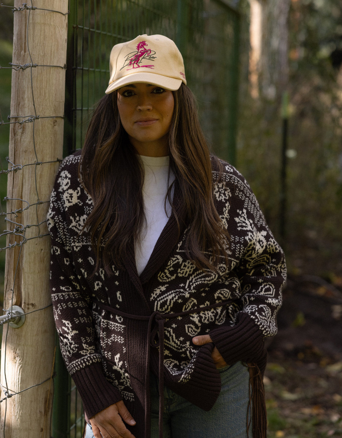 Woman in a cardigan wearing the Wild Card cap