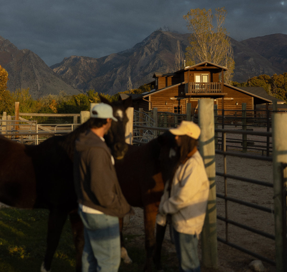 Couple by a barn with mountains behind
