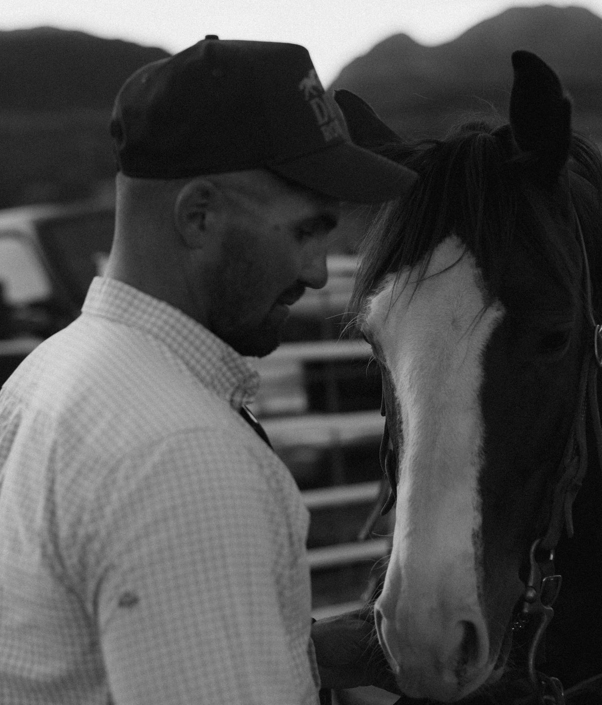 Bull River Supply man in a cap standing with his horse