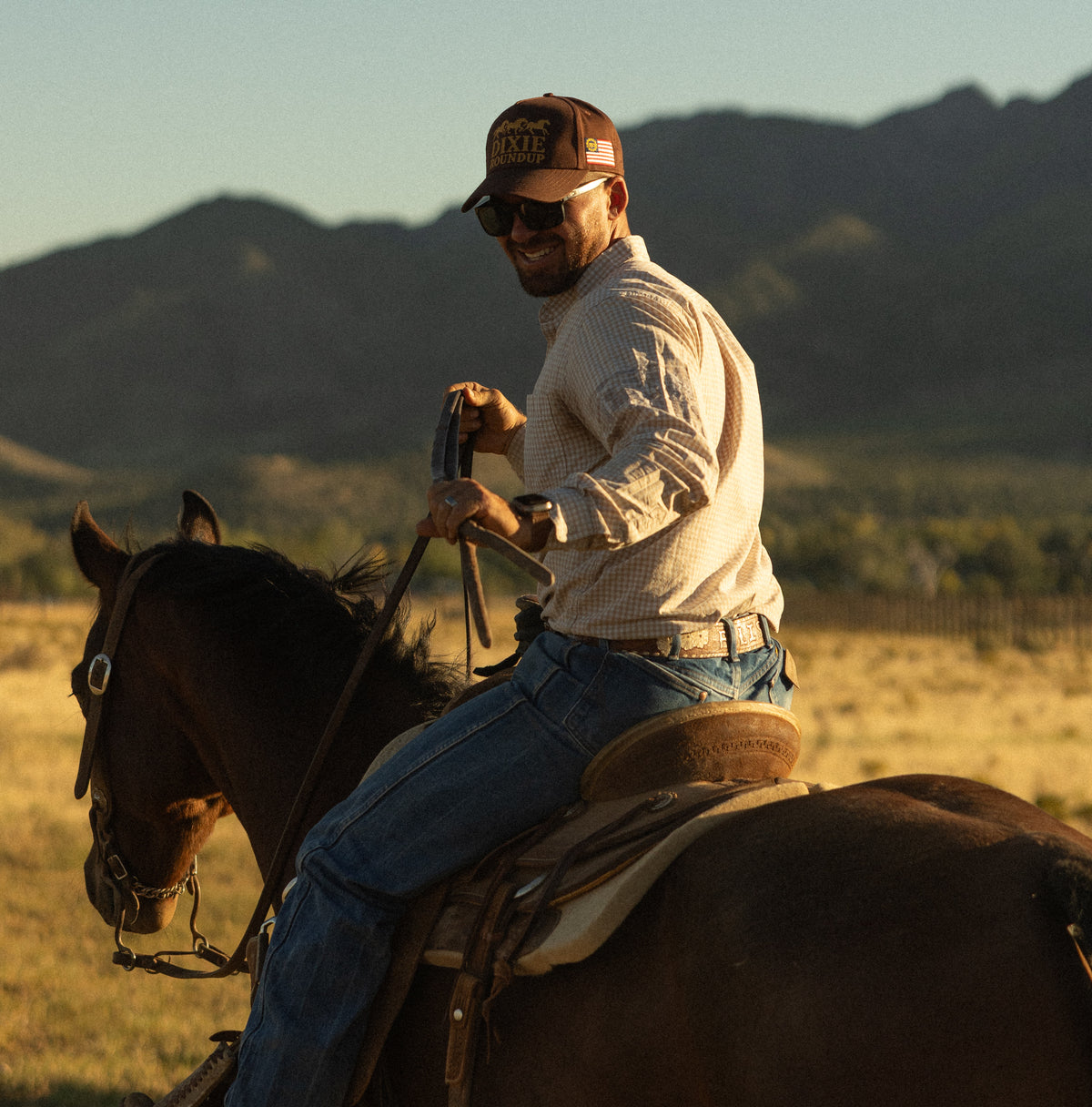 Bull River Supply cowboy on horseback with rope at sunset